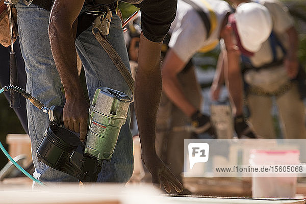 Carpenters working with nail guns at a construction site