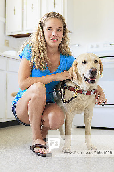 Frau mit Sehbehinderung in der Küche mit ihrem Diensthund