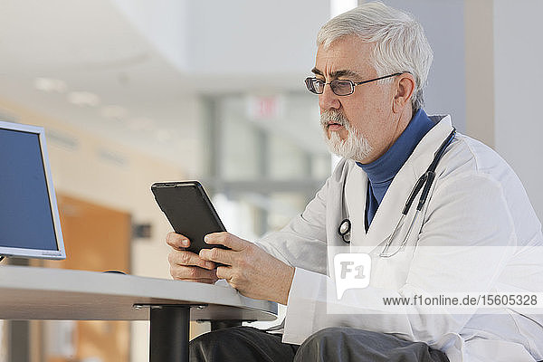 Doctor with Muscular Dystrophy looking at his tablet