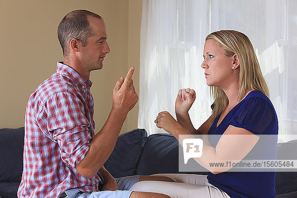 Husband and wife with hearing impairments signing 'work' in American sign language