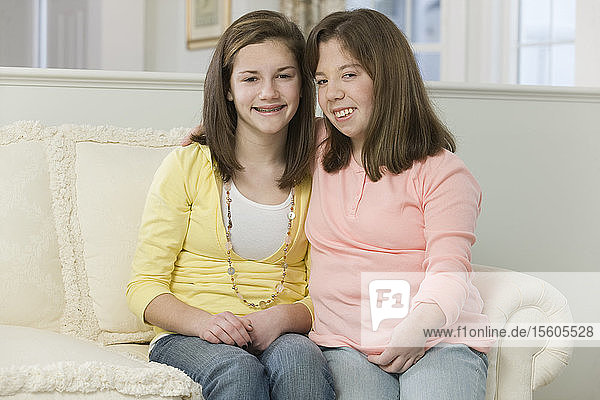 Zwei zusammensitzende Mädchen im Teenageralter  eines mit Geburtsfehler
