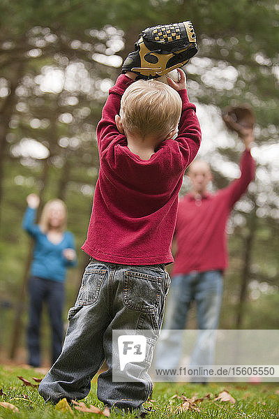Junge spielt mit seinen Eltern Baseball und kommuniziert mit Hilfe der Gebärdensprache