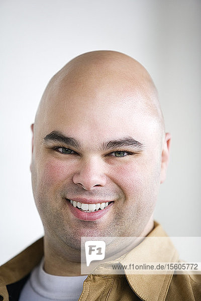 Portrait of a bald headed man smiling.
