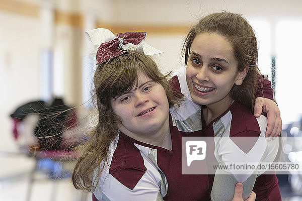 Porträt von zwei Cheerleadern  die sich umarmen  einer davon mit Down-Syndrom