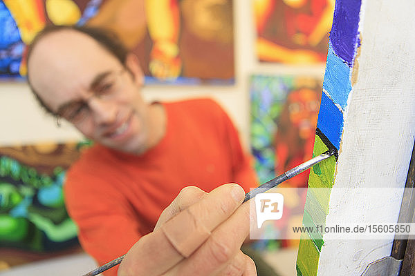 Mann mit Asperger-Syndrom malt in seinem Kunstatelier