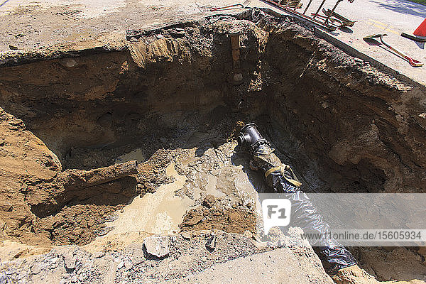 Section of new water main and old piping in street hole