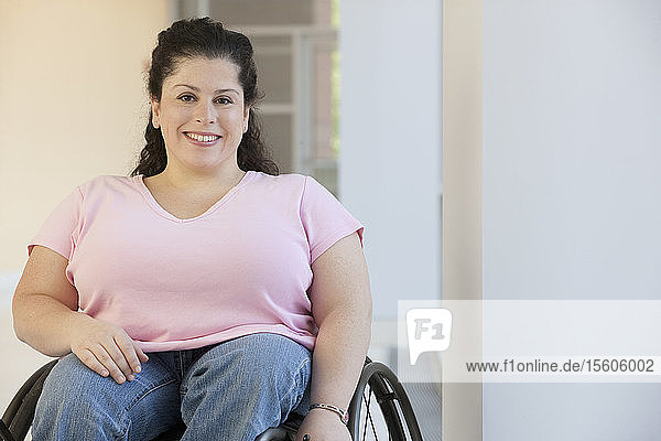 Frau mit Spina Bifida sitzt im Rollstuhl und lächelt