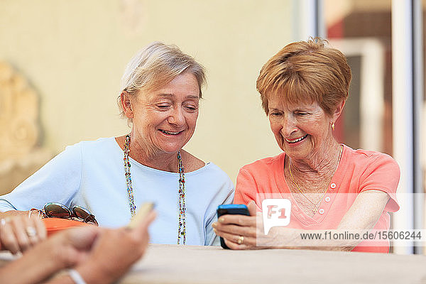 Ältere Freunde schauen auf ein Smartphone