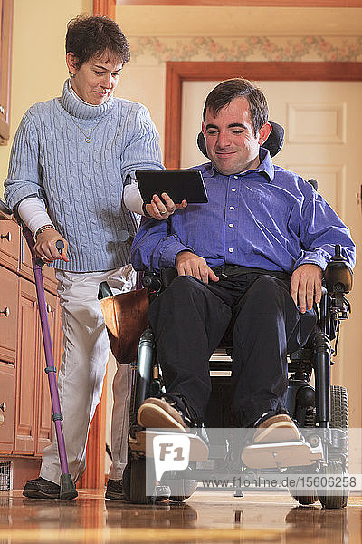 Ehepaar mit Cerebralparese schaut auf ihr Tablet