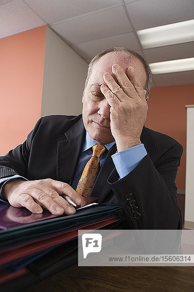 View of an exhausted businessman sitting in an office.