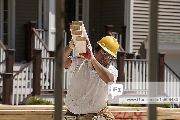 Zimmermann trägt Bretter auf einer Baustelle