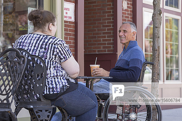 Woman with Visual Impairment sitting at a cafÃƒÂ© with her father