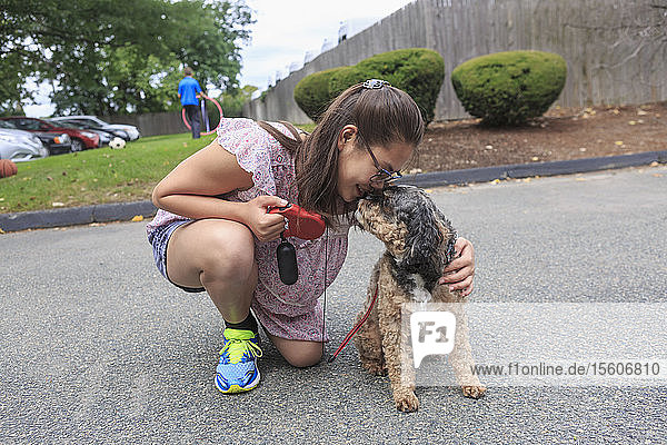 Teen girl who has Learning Disability playing with her dog