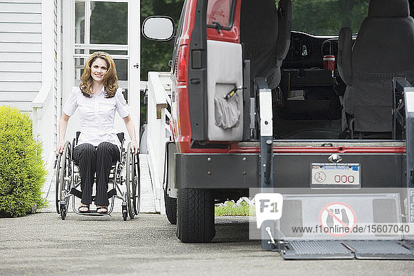 Porträt einer lächelnden  im Rollstuhl sitzenden erwachsenen Frau mit einer Wirbelsäulenverletzung