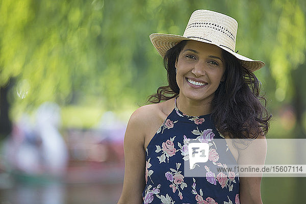 Porträt einer glücklichen hispanischen Frau  die in einem Park lächelt