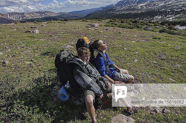 Boys rest exhausted on a rock after a steep climb up to a high alpine bench below Kings Peak  on the fourth day of Troop 693's six day backpacking trip in the High Uintas Wilderness Area  Uintas Range  Utah