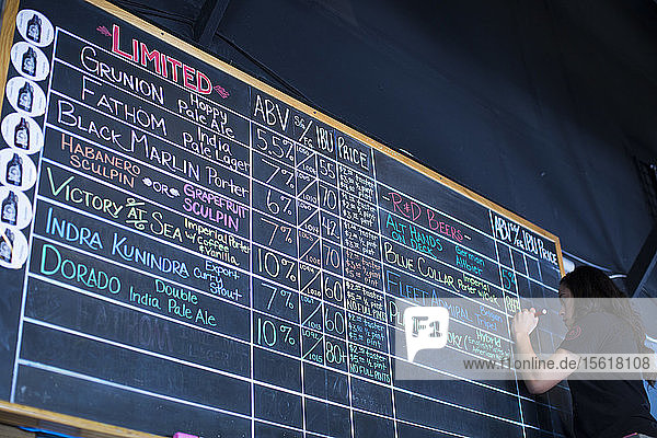 Eine Frau aktualisiert die Liste der Biere im Ballast Point Tasting Room in Miramar  Kalifornien.