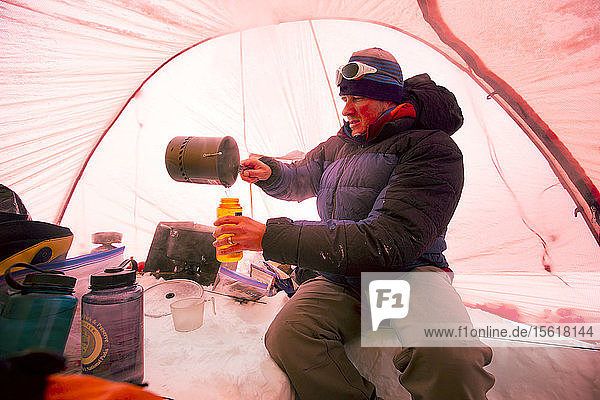 Ein Bergsteiger schmilzt Schnee  um Trinkwasser zu gewinnen  in einem Zelt im High Camp am Denali in Alaska. Am frühen Morgen wollen sie einen Gipfelsturm auf den höchsten Berg Nordamerikas unternehmen.