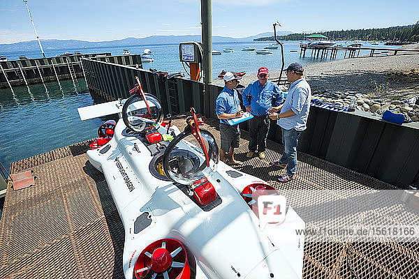 Three men preparing prototype personal two-man submarine for test dive  Homewood Marina  Lake Tahoe  California  USA