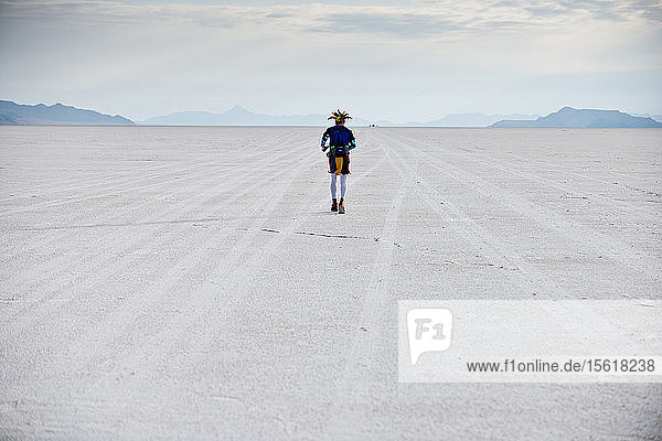 A male athlete dressed like a jester runs across the Bonneville Salt Flats during the Salt Flats 100 in Bonneville  Utah.