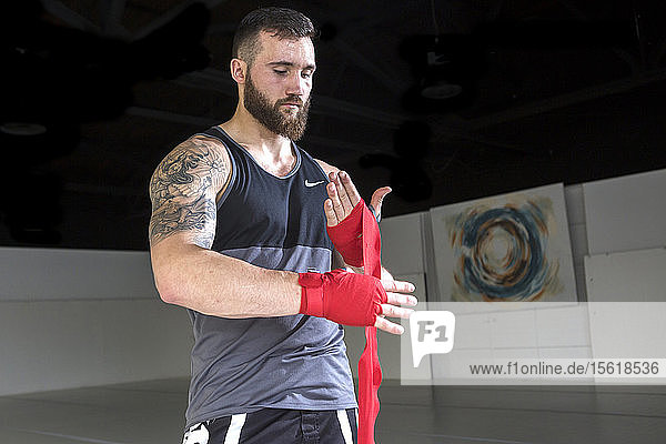 Up and coming mixed martial arts fighter  Sean Lally  wraps his hands before training at gym.
