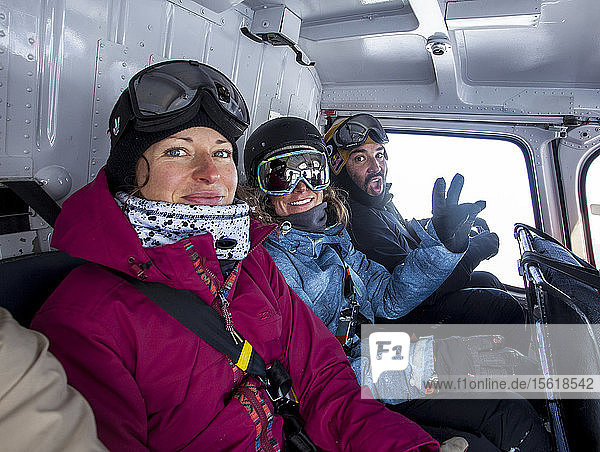 Die Profi-Snowboarder Helen Schettini  Robin Van Gyn und ihr Filmer fliegen an einem sonnigen Tag in Haines  Alaska  in einem Hubschrauber zum Snowboarden.