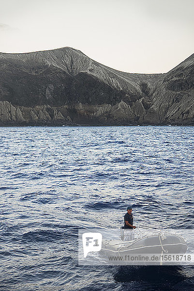 Photograph of man in motorboat near coastline of San Benedicto Island  Revillagigedo Islands  Colima  Mexico