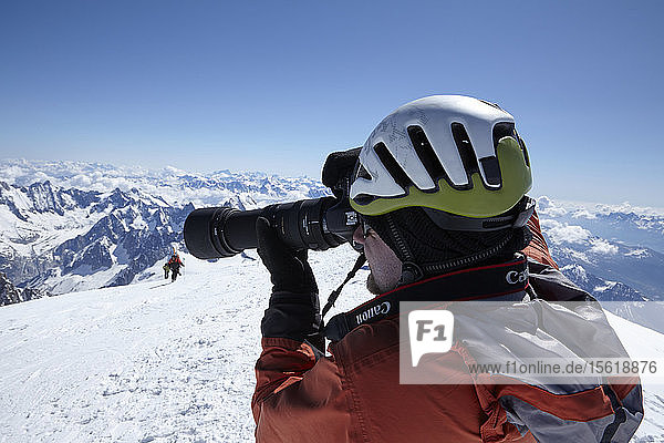 Hochschnitt eines Mannes  der schneebedeckte Berge fotografiert  Schweiz