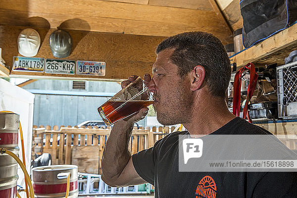 Seitenansicht eines reifen Mannes  der selbst gebrautes Bier probiert  Bishop  Kalifornien  USA
