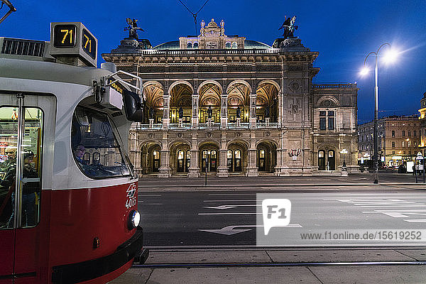 Illuminated Vienna State Opera at night with tramway in foreground Vienna Austria