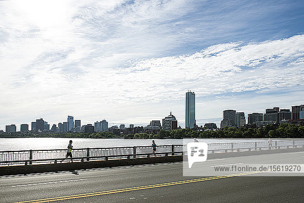 Seitenansicht von Menschen  die auf einer Brücke am Charles River laufen und gehen  Boston  Massachusetts  USA