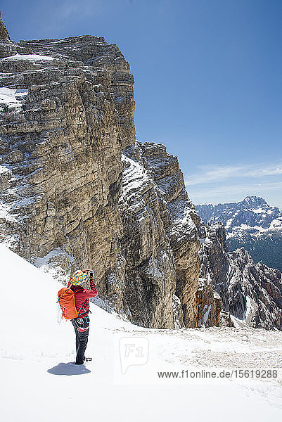 Mann  der ein Foto auf dem Klettersteig Ivano Dibona in den Dolomiten  Italien  macht