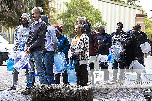 Capetonians line up with their water containers at the Newlands spring in a suburb of Cape Town. The spring  whose water is supplied by nearby Table Mountain  has flowed without interruption since record keeping started in South Africa  but has only recently becoming a critical collection point. Because of rising water costs and tight restrictions on municipal water usage  local residents come to the spring to fill up on the clean mountain water they use primarily for drinking and cooking.