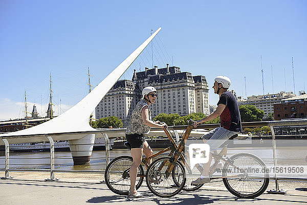 Ein Paar auf Bambus-Fahrrad vor der Puente De La Mujer am Puerto Madero in Buenos Aires  Argentinien