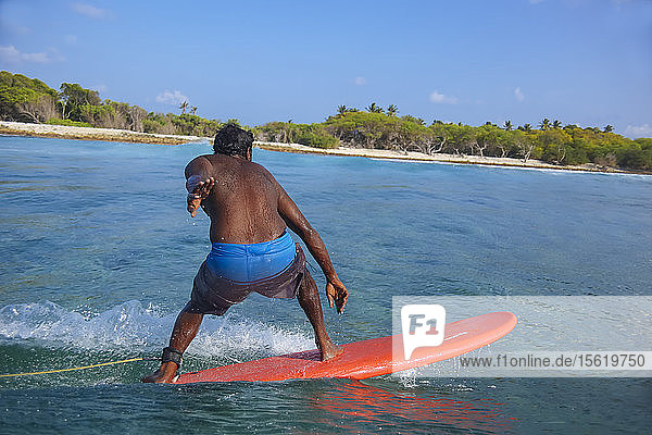 Mann ohne Hemd beim Surfen in Küstennähe  Male  Malediven