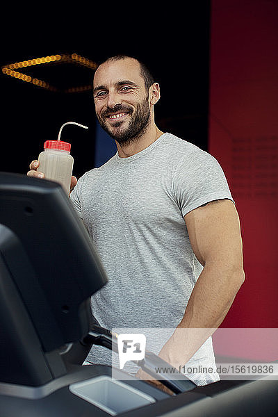 Muscular man running on a treadmill in a fitness club  sport in the fitness club