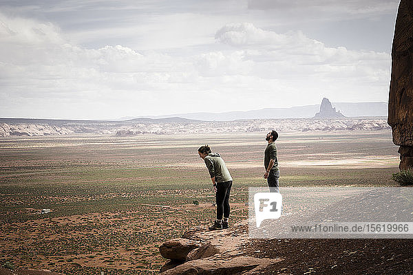 Zwei Menschen blicken über die Wüste des Monument Valley hinaus