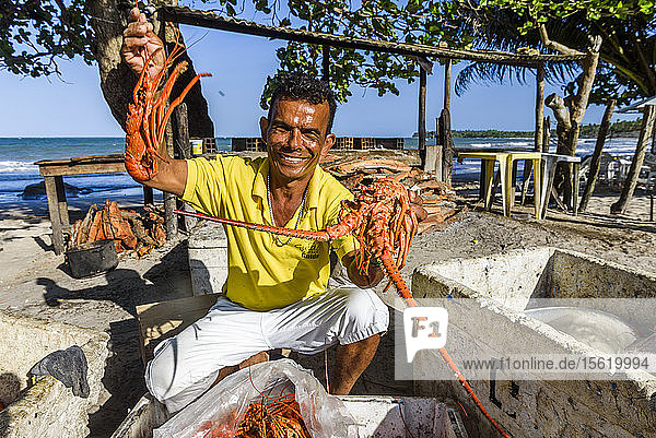 Lächelnder lokaler Restaurantbesitzer zeigt frische Hummer  Insel Boipeba  Süd-Bahia  Brasilien