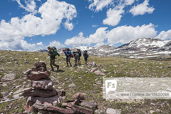 Jungen der Pfadfindergruppe 693 wandern am vierten Tag eines sechstägigen Ausflugs durch die High Uintas Wilderness Area  Uintas Range  Utah  über den Tungsten Pass (11.500 Fuß)  umgeben von schneebedeckten Gipfeln.