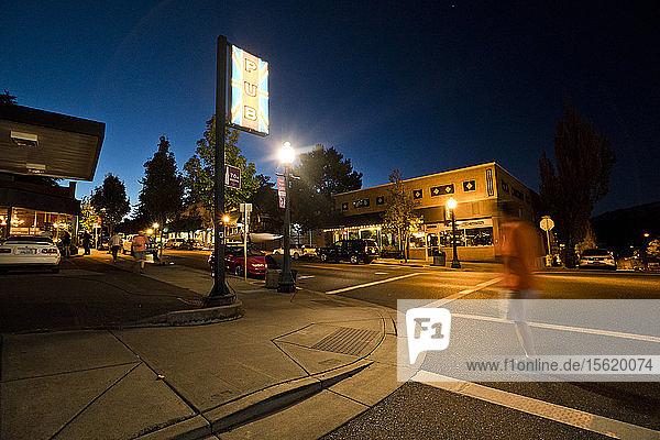 People walk the streets of Hood River Oregon at dusk (motion blur).