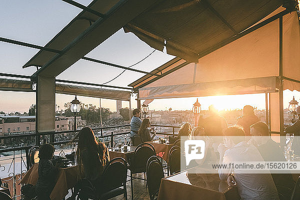 Blick auf Menschen auf der Terrasse eines Restaurants in der Nähe des Jemaa el-Fnaa bei Sonnenuntergang  Medina  Marrakesch  Marokko