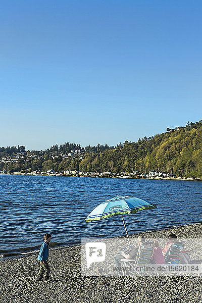 Familie mit zwei Kindern entspannt sich gemeinsam am Küstenstrand  Seattle  Washington  USA