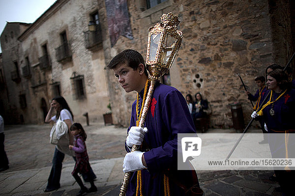 An altar boy holds a lump during Easter Holy Week in Caceres  Extremadura  Spain