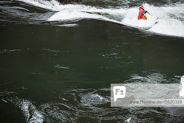 Ein Mann surft auf einer Welle im Abschnitt der Alberton-Schlucht des Clark Fork River