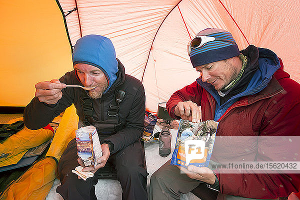 Zwei Bergsteiger essen Trockenfutter in einem Zelt im High Camp am Denali in Alaska. Am frühen Morgen wollen sie einen Gipfelsturm auf den höchsten Berg Nordamerikas unternehmen.