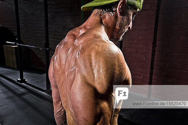 A crossfit athlete rests between sets at an old gritty gym in San Diego CA.