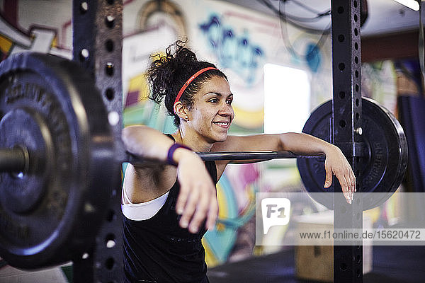 Lächelnde Athletin Frau entspannt sich im Crossfit-Fitnessstudio