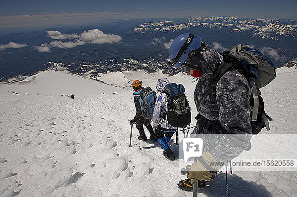 Boys age 13-17 from the Venturing Crew 191 from Glendora  California put a year of training into practice as they attempt to reach the summit of Mount Shasta via the Avalanche Gulch route  Shasta Trinity National Forest  Northern California. Mount Shasta  is a massive  glaciated volcano and at 14 179 feet  is the second highest peak in the Cascade Range  and the fifth highest in California; it is not connected to any other peak and rises abruptly 10 000 feet from the surrounding terrain. The scouts from Venturing Crew 191  (Venturing Crews are a branch of the Boy Scouts that concentrate on adventurous activities) had prepared for a year for their ascent of Mount Shasta  this was their first experience with climbing on steep snow and they were assisted in their ascent by guides from SWS Mountain Guides. Josh Kolbach (right)  Jeremy Kolbach and Sandy Howlett of Venturing Crew 191 rope up to descend the steep  icy slopes above Avalanche Gulch  on their descent from the summit of Mount Shasta  14 179 feet-the whole climb round trip from their high camp took nearly 14 hours and covered 4200 feet of climbing  Shasta Trinity National Forest  California.