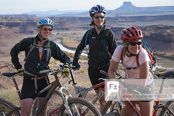 Friends explore the Utah desert in autumn with an extended mountain biking adventure on the White Rim Trail  Canyonlands National Park near Moab  Utah.