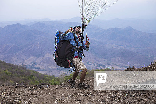 Paragliding pilots check a new paraplanirists spot on Mantar mountain  West Sumbawa  Indonesia.